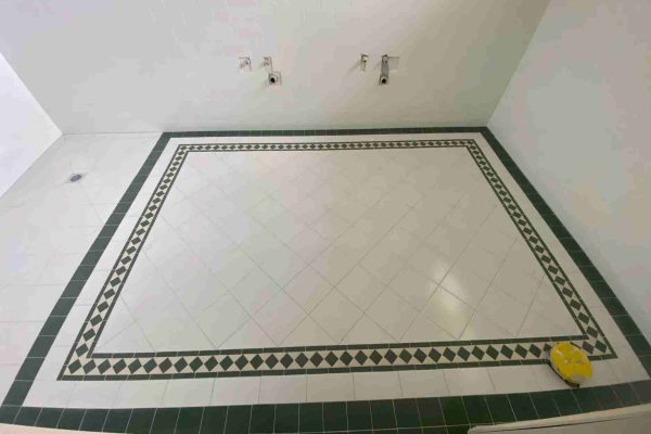 A classic bathroom floor in Marsfield, NSW, with a green and white mosaic tile design